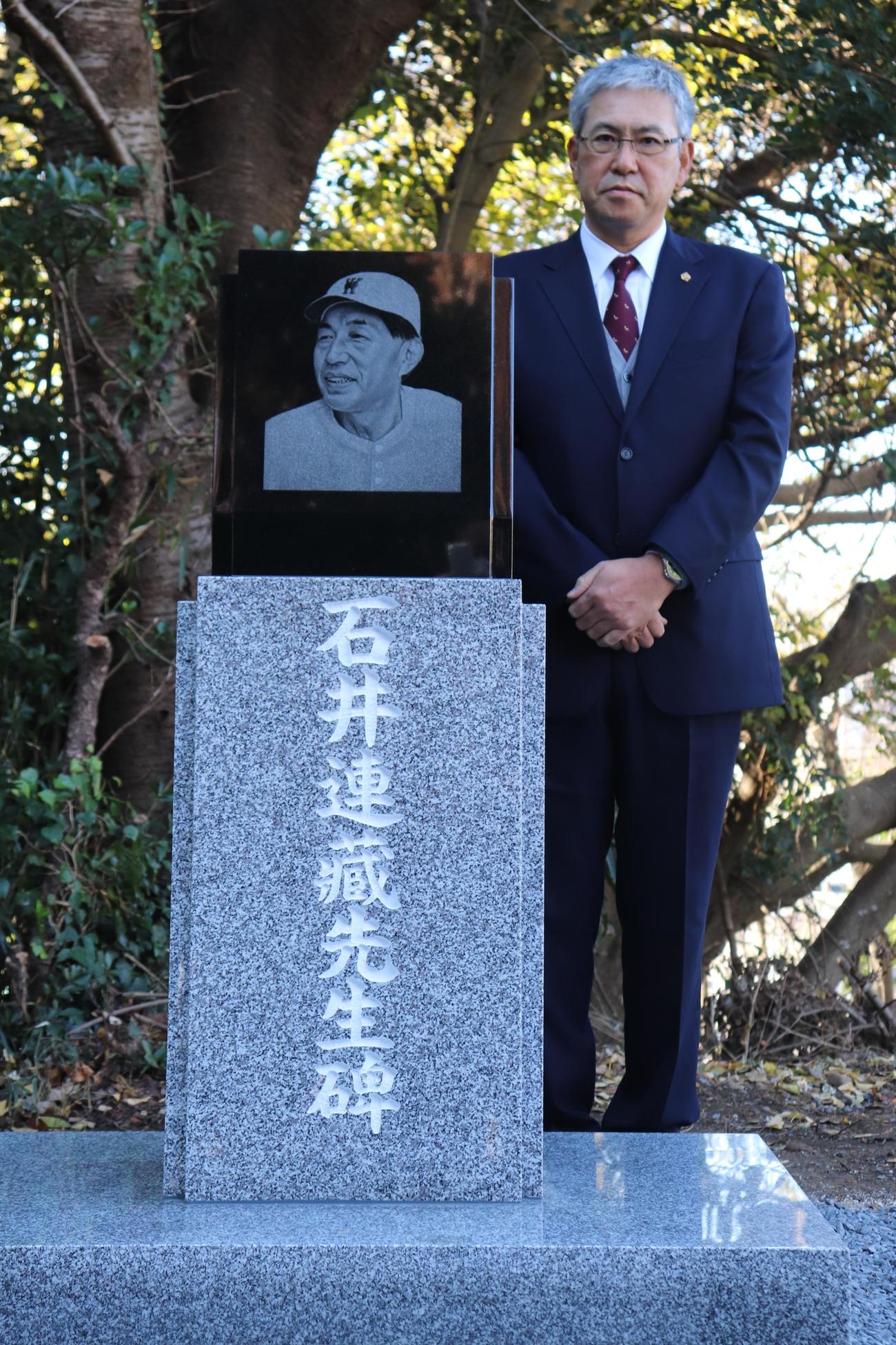 石井連蔵氏の石碑の横に立つ早大・小宮山監督（撮影・古川真弥）