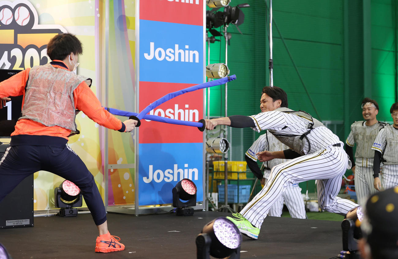 ファン感謝デーで東京五輪のフェンシング男子エペ団体金メダリストの宇山（左）とフェンシング対決する阪神藤浪（撮影・前田充）