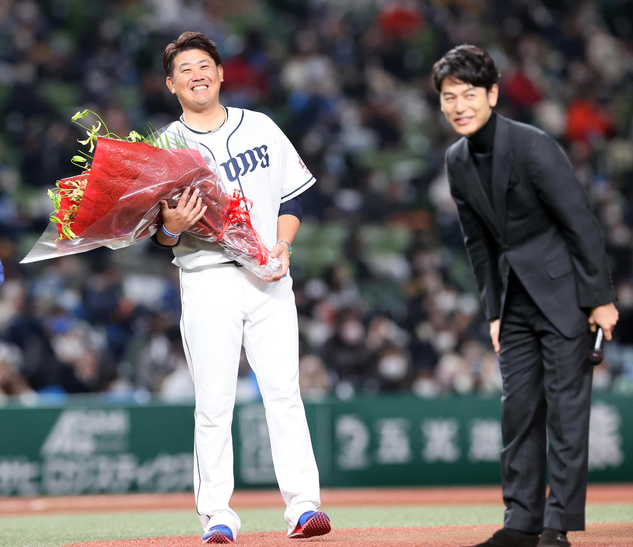 西武ライオンズファンフェスタ後の引退セレモニーで、サプライズで花束贈呈に駆けつけた妻夫木聡（手前）に笑顔を見せる松坂（撮影・浅見桂子）