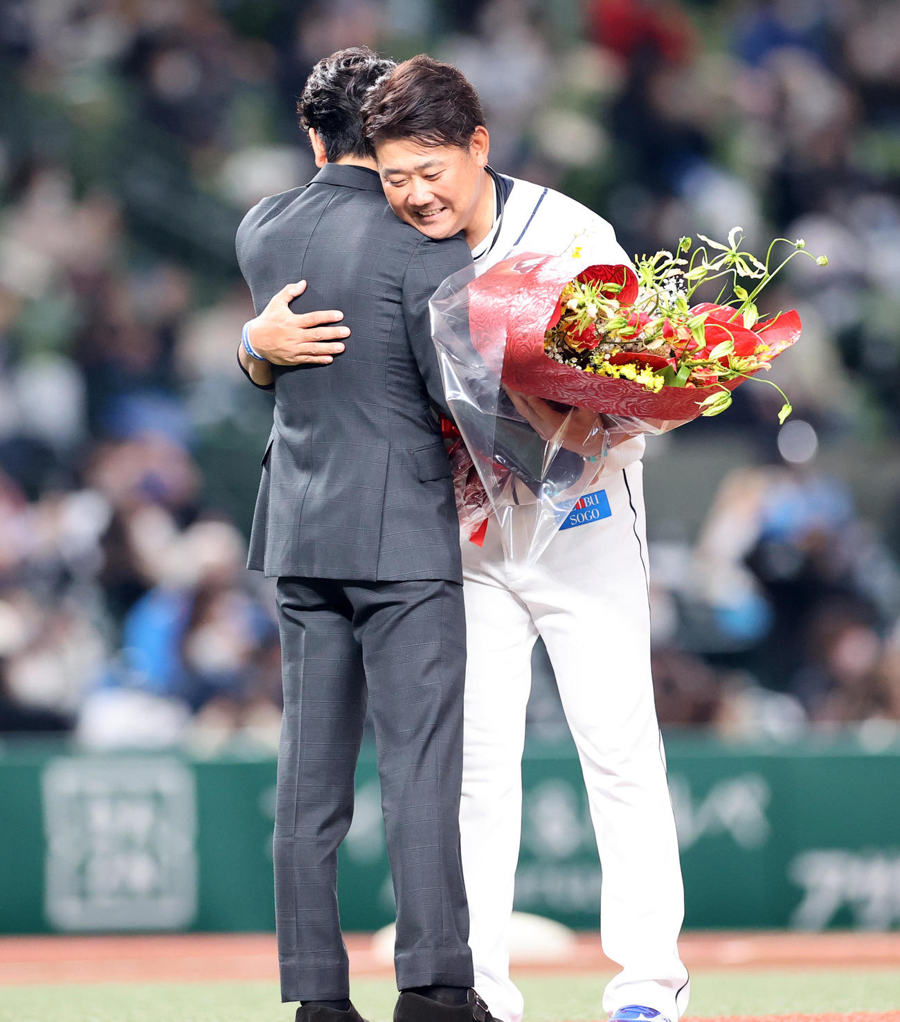 西武ライオンズファンフェスタ後の引退セレモニーで、サプライズで花束贈呈に駆けつけた妻夫木聡（手前）と抱擁する松坂（撮影・浅見桂子）