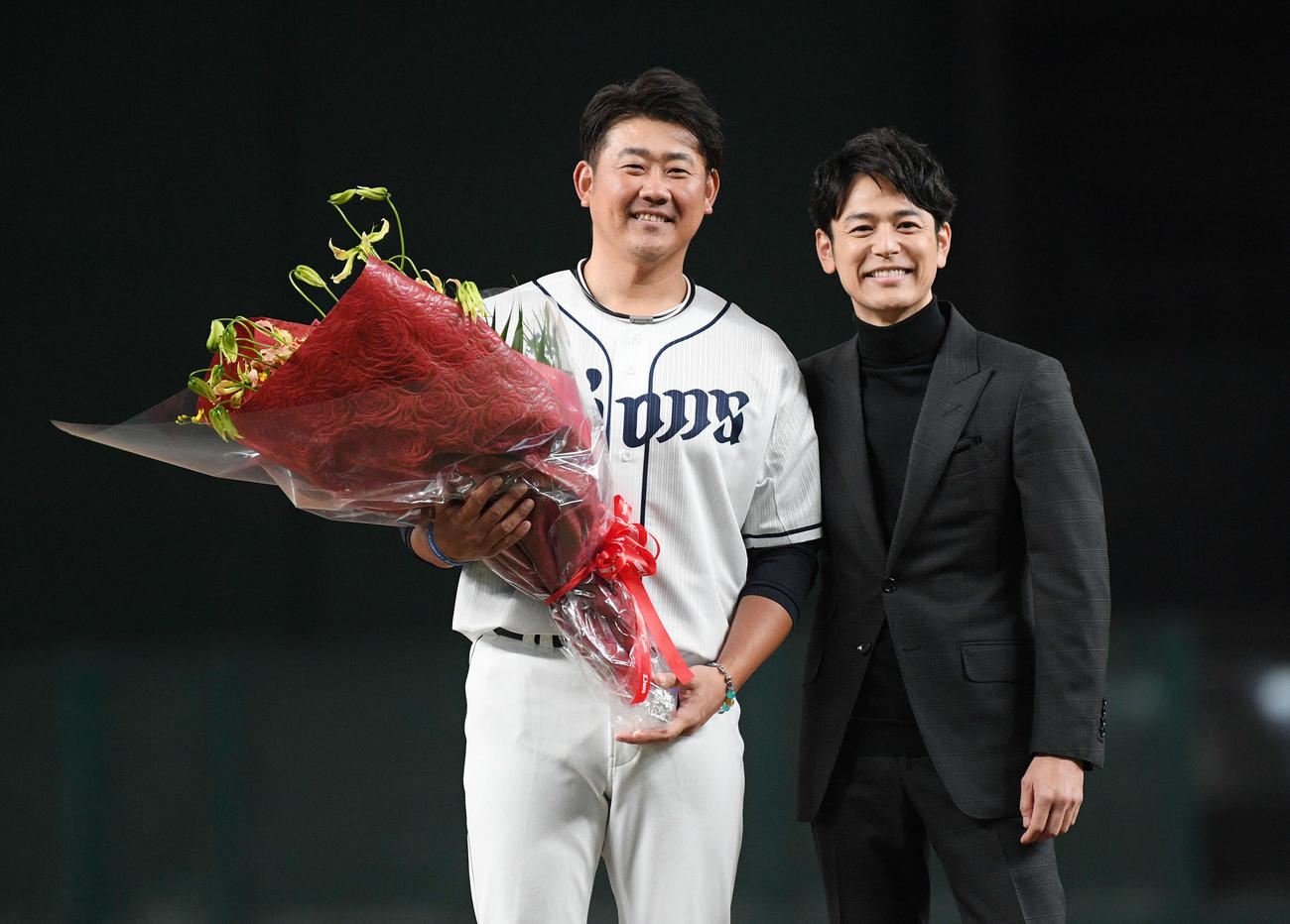西武松坂（左）は引退セレモニーで妻夫木聡から花束を受け取り記念撮影する（撮影・滝沢徹郎）
