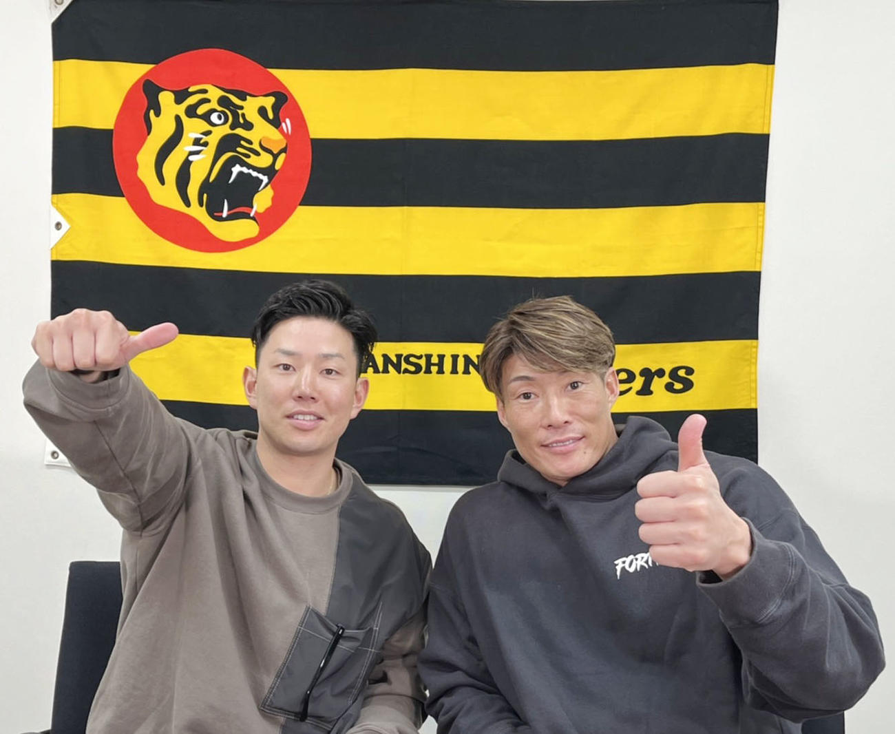 「オンライントークショー」に出演し、ポーズを取る糸原（左）と糸井（球団提供）