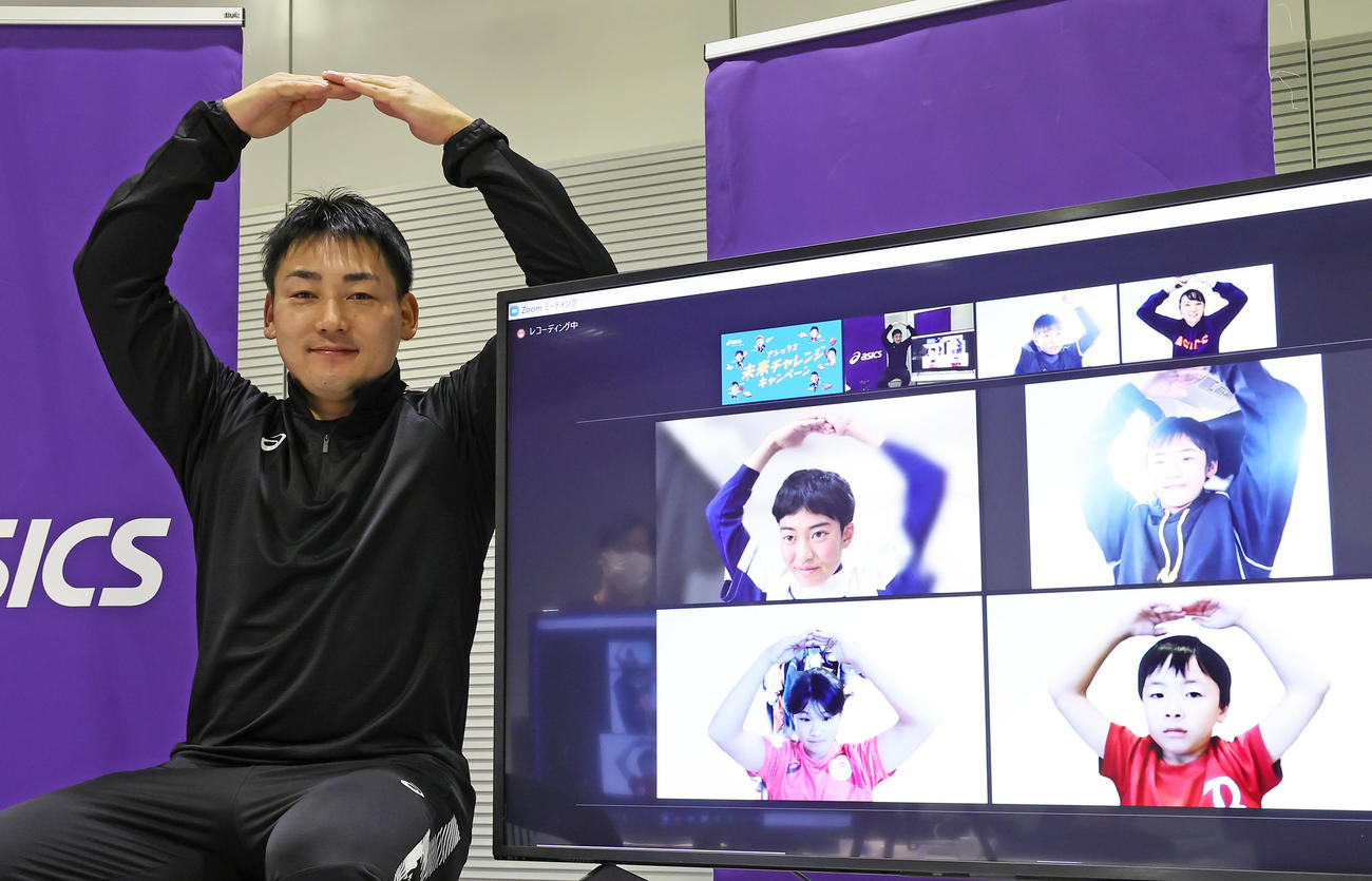 オンラインで参加した子どもたちと「丸ポーズ」を決める巨人丸（撮影・足立雅史）