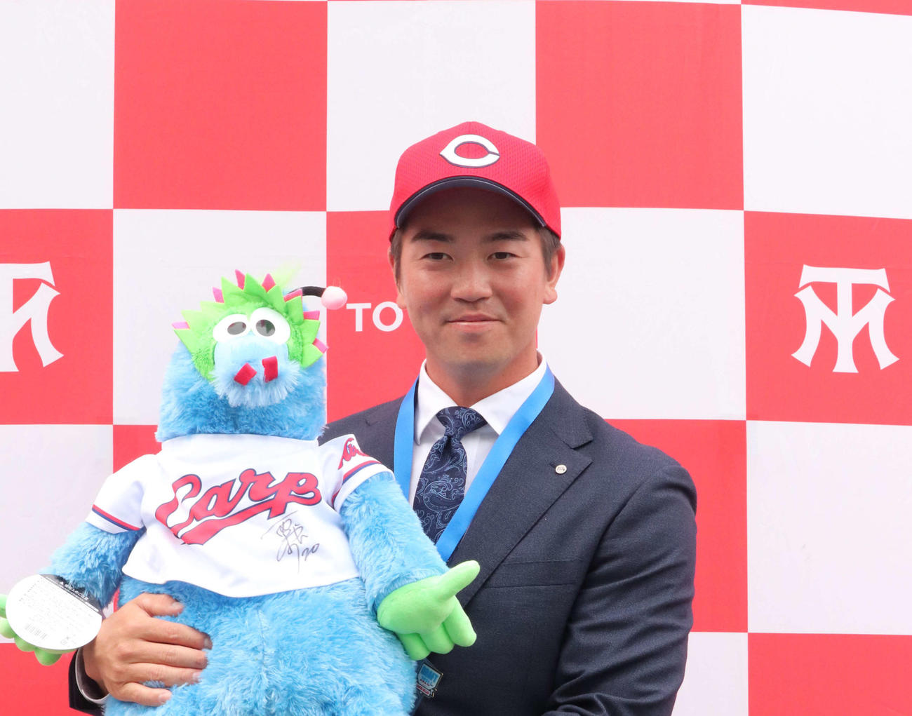 栗林からトヨタ自動車に贈られたスラィリー人形を手に笑顔を見せる中村健人（2021年10月21日撮影）