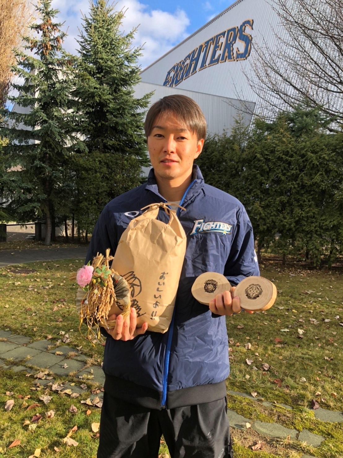 日本ハムの「ふぁい田！ATSUMAプロジェクト」で参加者に発送された米などを持つ玉井（球団提供）