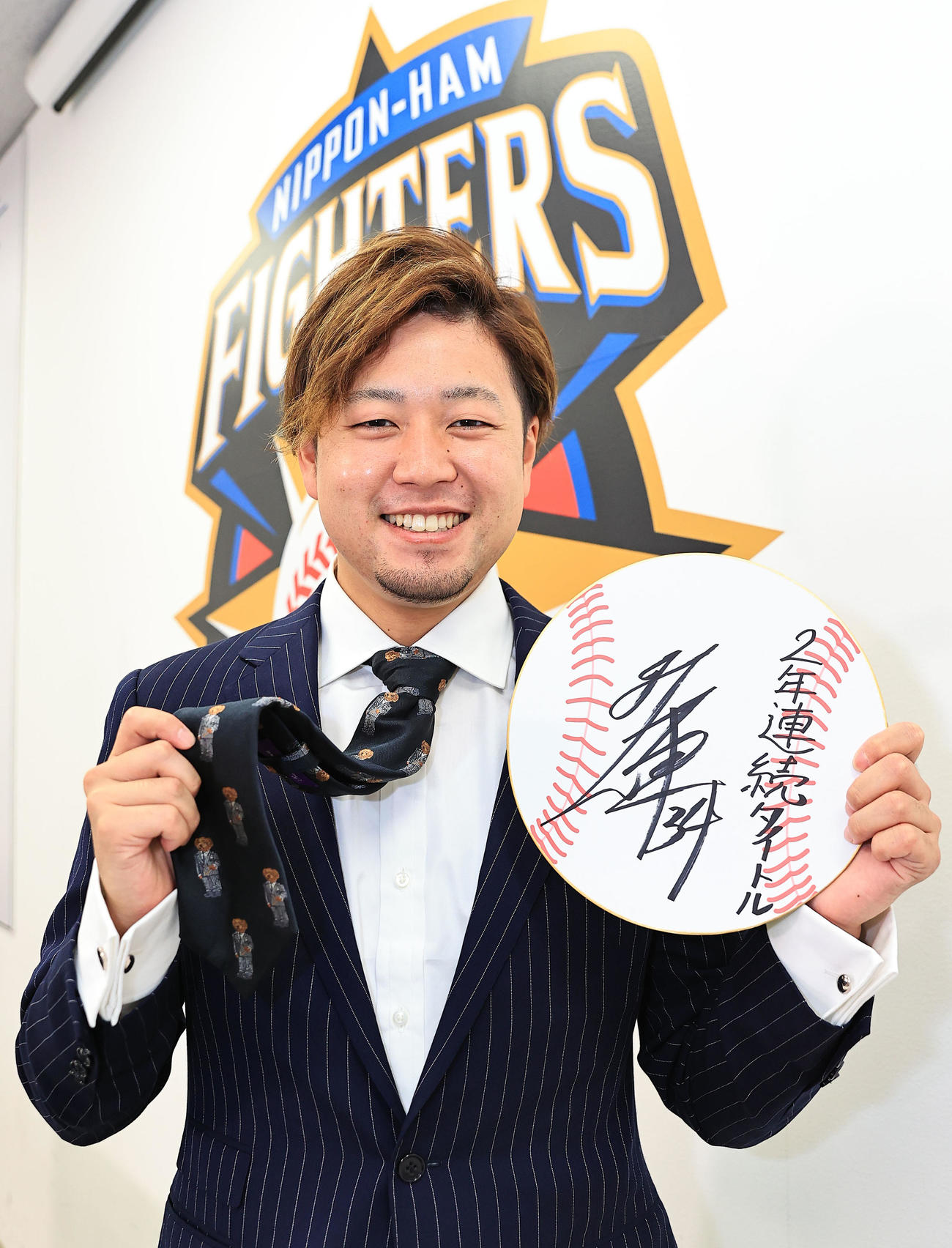 契約更改交渉を終え、来季の目標「2年連続タイトル」と書き記しクマ柄のネクタイをアピールする日本ハム堀（代表撮影）