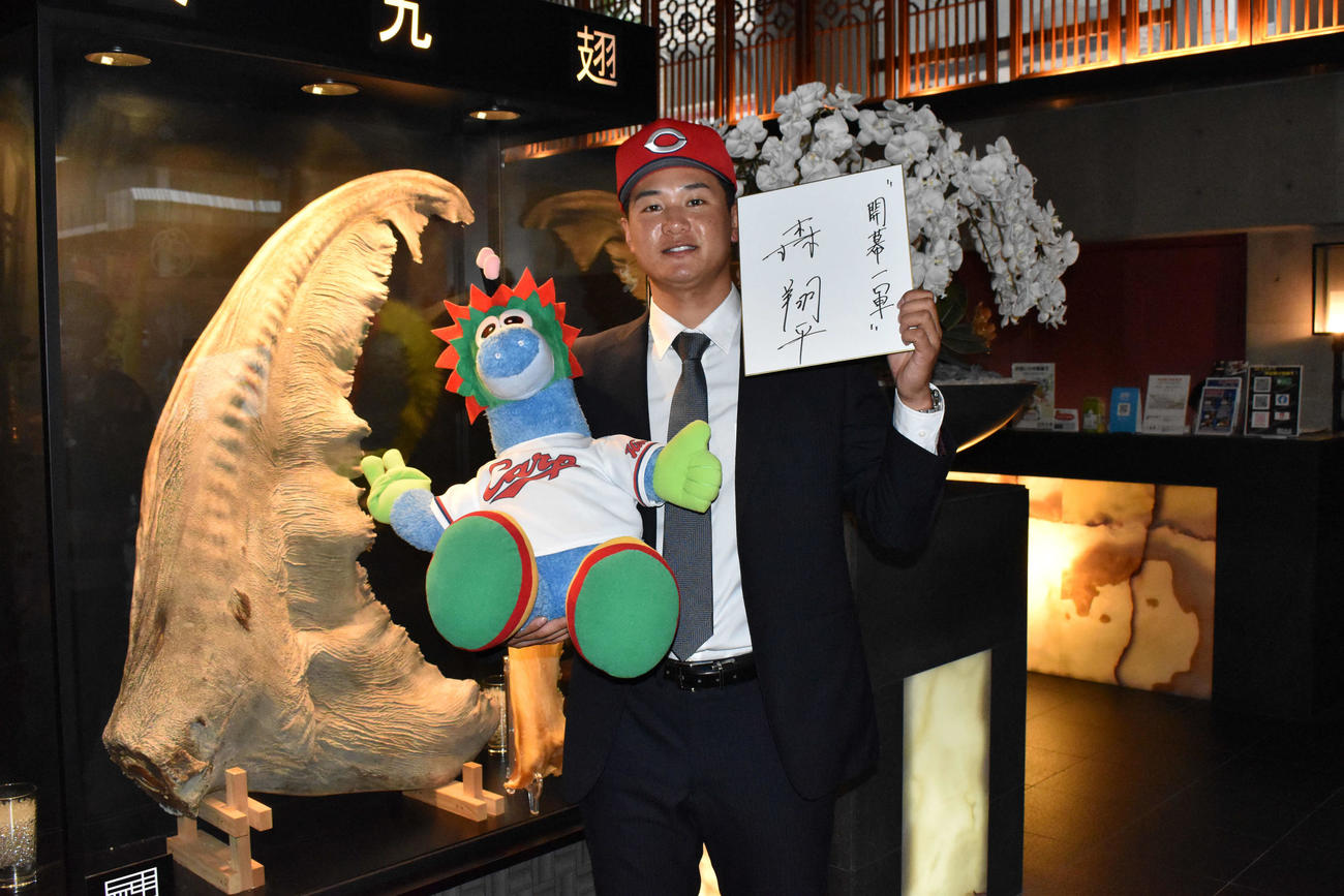 ウバザメの腹ビレをバックに、写真撮影に応じる広島ドラフト2位の三菱重工West・森（撮影・古財稜明）