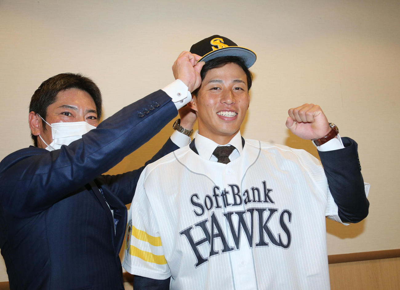 仮契約を終えた野村勇は笑顔でガッツポーズ、左は稲嶺誉スカウト（撮影・梅根麻紀）