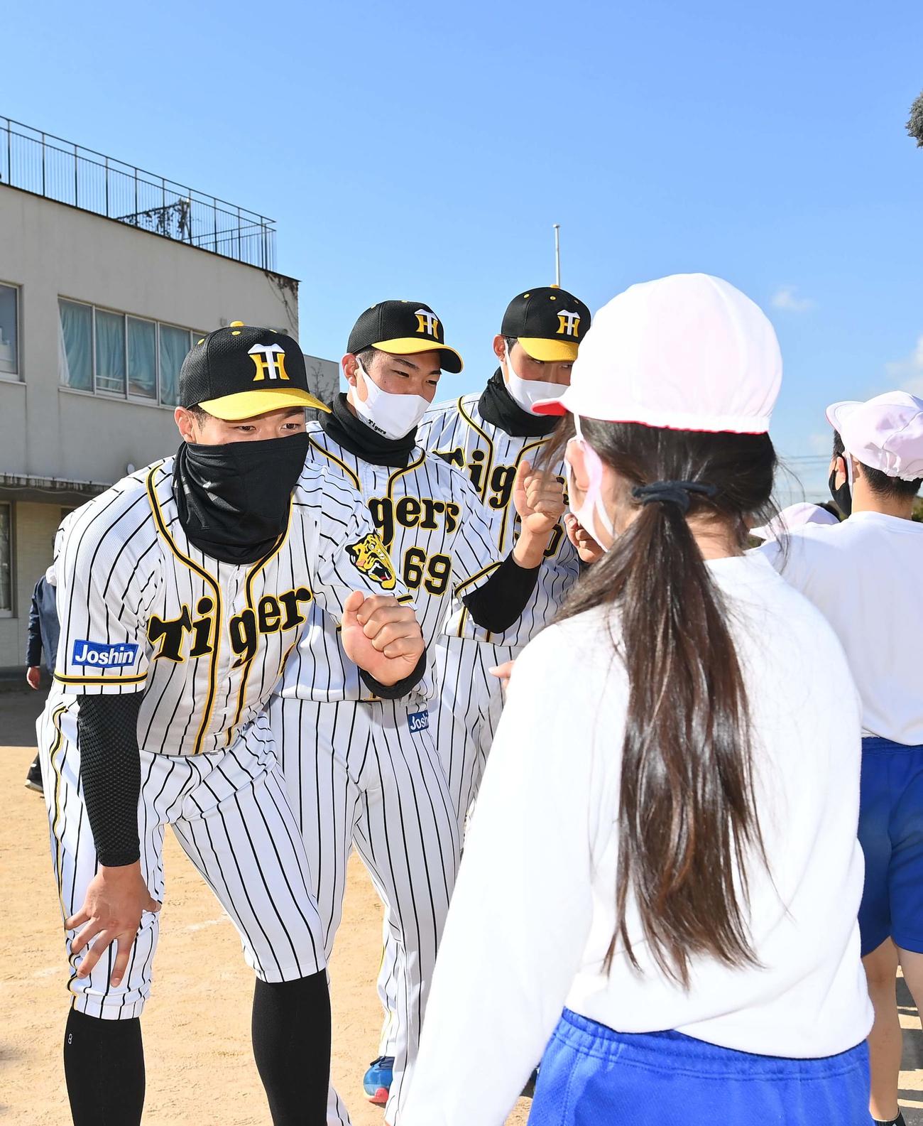 児童とグータッチする佐藤輝（左）ら阪神ナイン（撮影・上田博志）