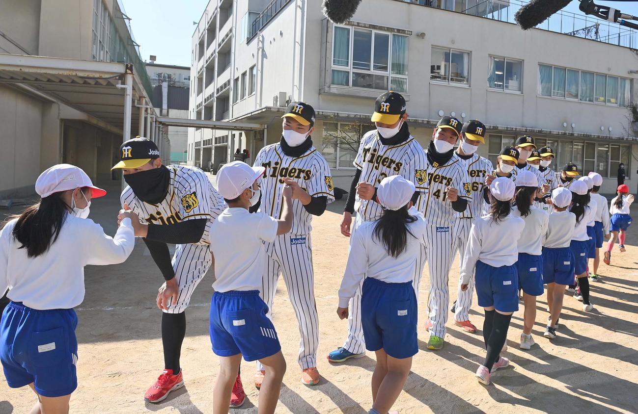 児童とグータッチする佐藤輝（左）ら阪神ナイン（撮影・上田博志）