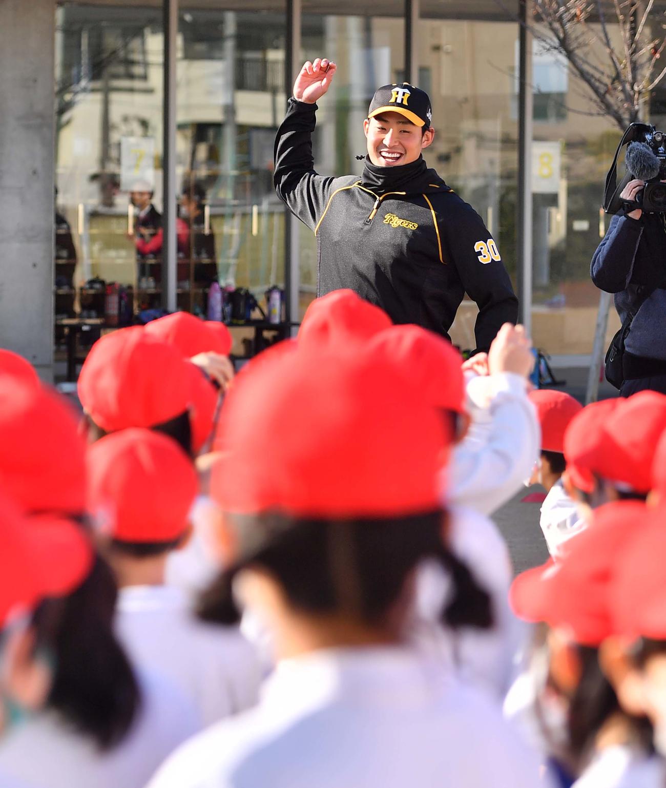 阪神佐藤蓮は児童にボールの投げ方を教える（撮影・上田博志）