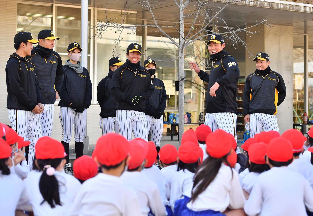 阪神佐藤蓮（右から2人目）は児童にボールの投げ方を教える（撮影・上田博志）
