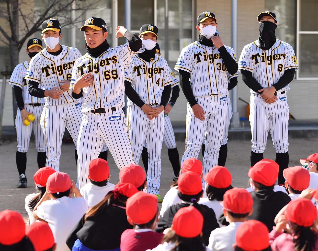 児童らにボールの投げ方を教える石井（撮影・上田博志）