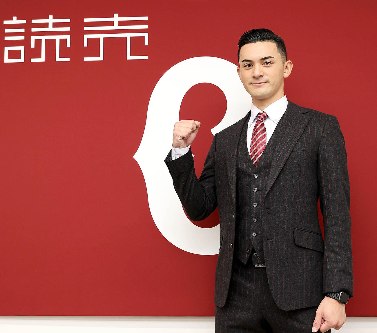 育成契約で入団した巨人鈴木は球団旗の前でガッツポーズ（球団提供）
