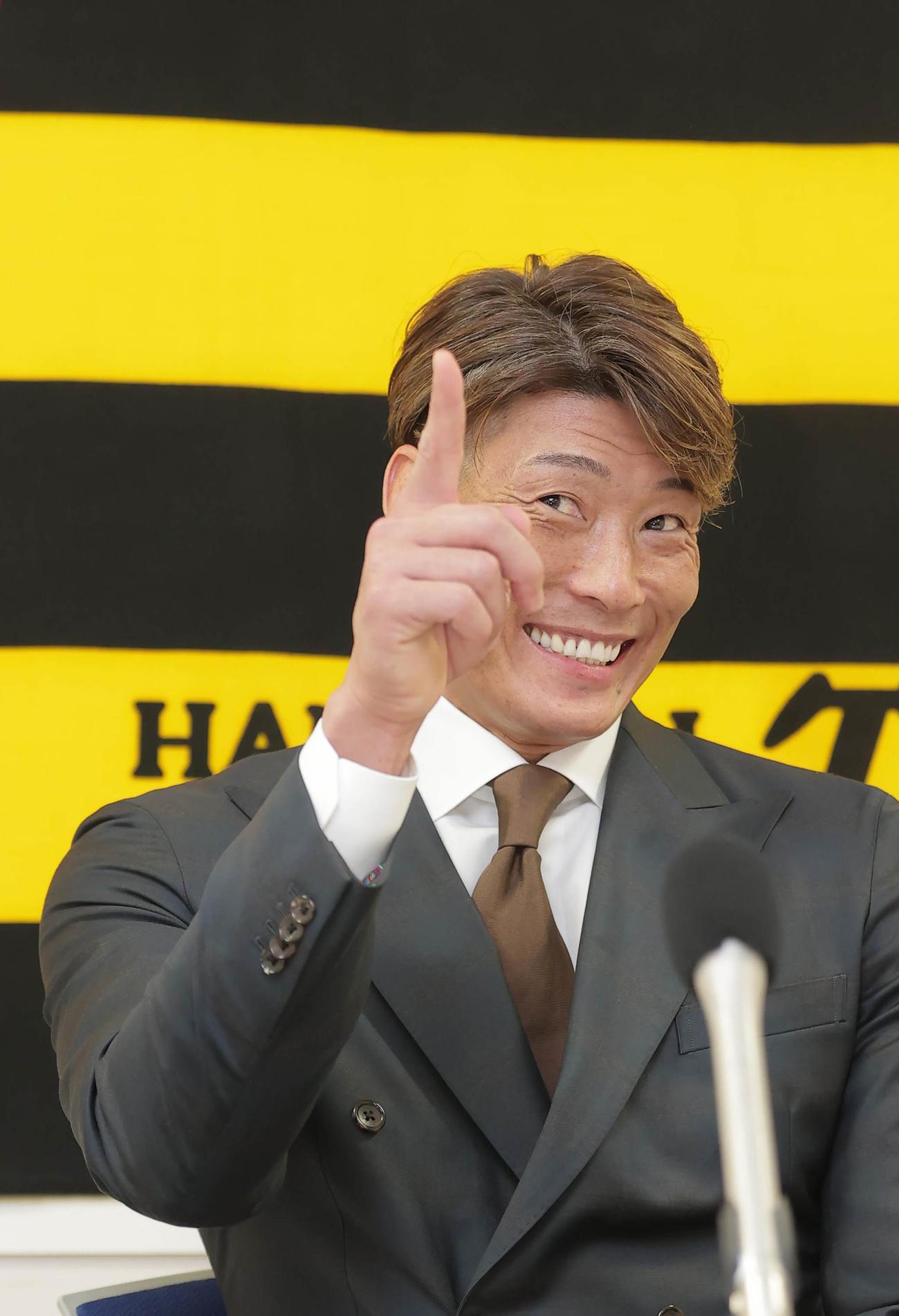 契約更改を終え会見中に近くを通った秋山拓巳に笑顔を見せる糸井嘉男