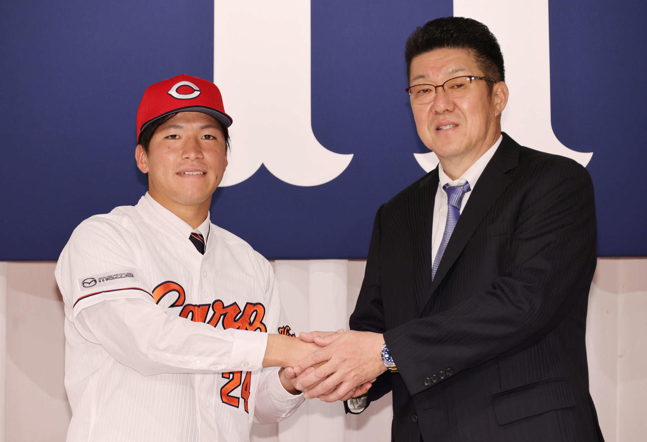 広島新入団選手発表会見　佐々岡監督と握手するドラフト1位の黒原（左）　（撮影・加藤孝規）