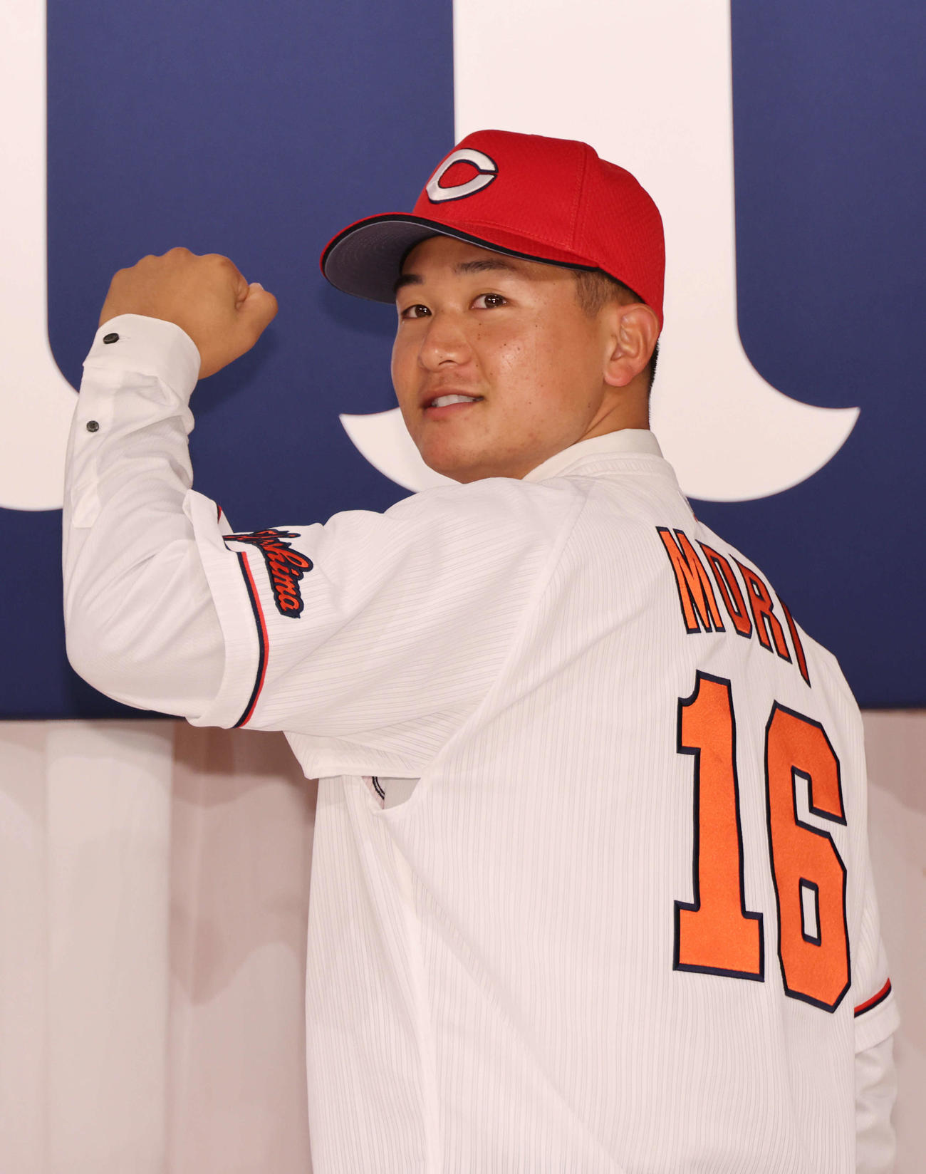 広島新入団選手発表会見　ポーズを決めるドラフト2位の森（撮影・加藤孝規）