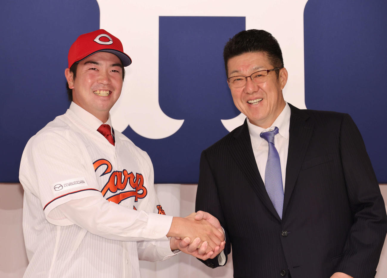 広島新入団選手発表会見　佐々岡監督と握手するドラフト3位の中村健（左）（撮影・加藤孝規）