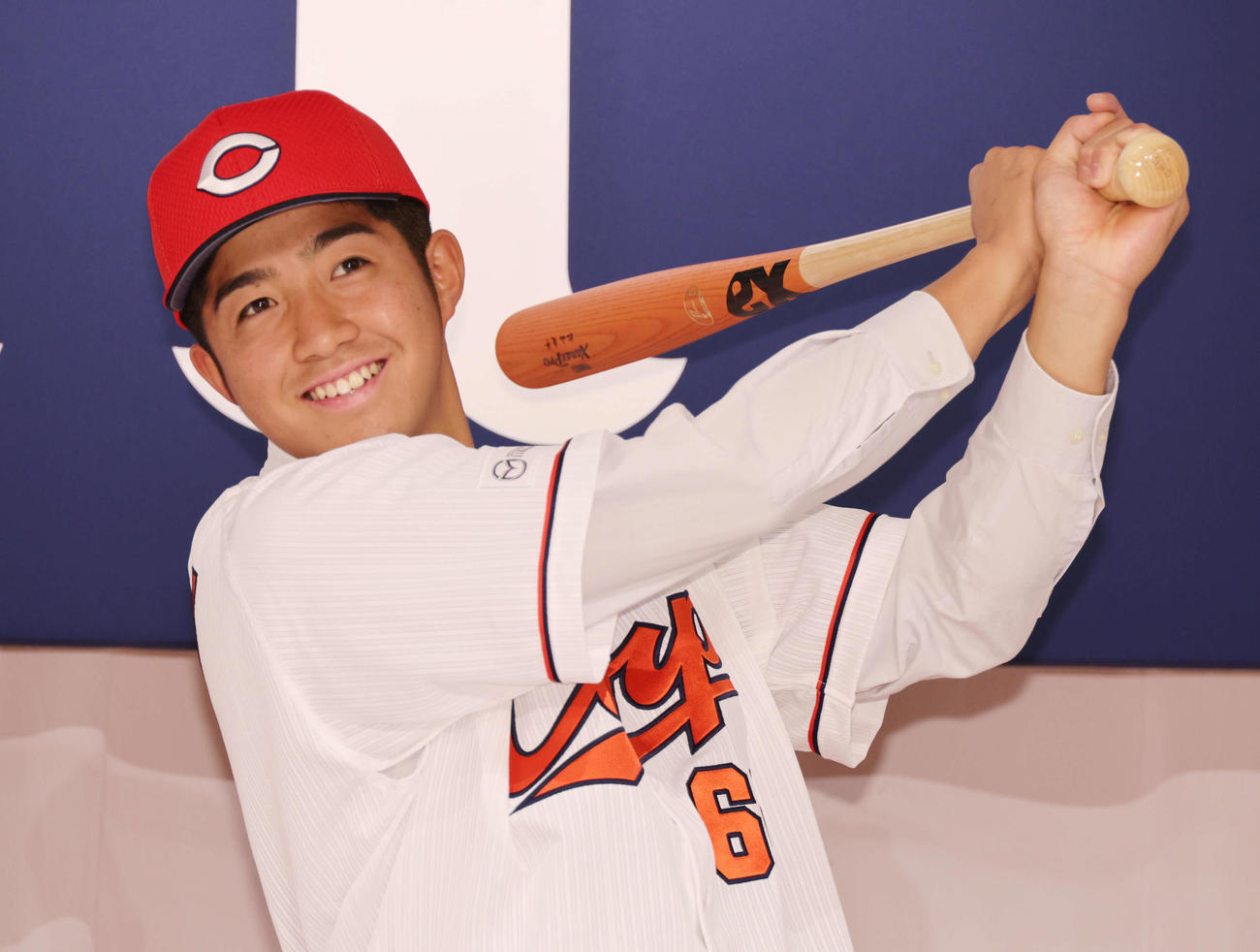 広島新入団選手発表会見　ポーズを決めるドラフト7位の高木（撮影・加藤孝規）