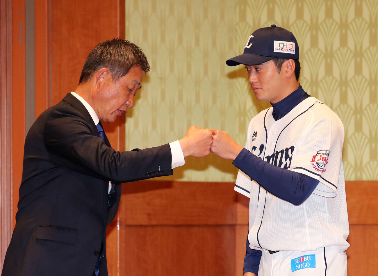 辻発彦監督（左）とグータッチする西武佐藤（撮影・鈴木正人）