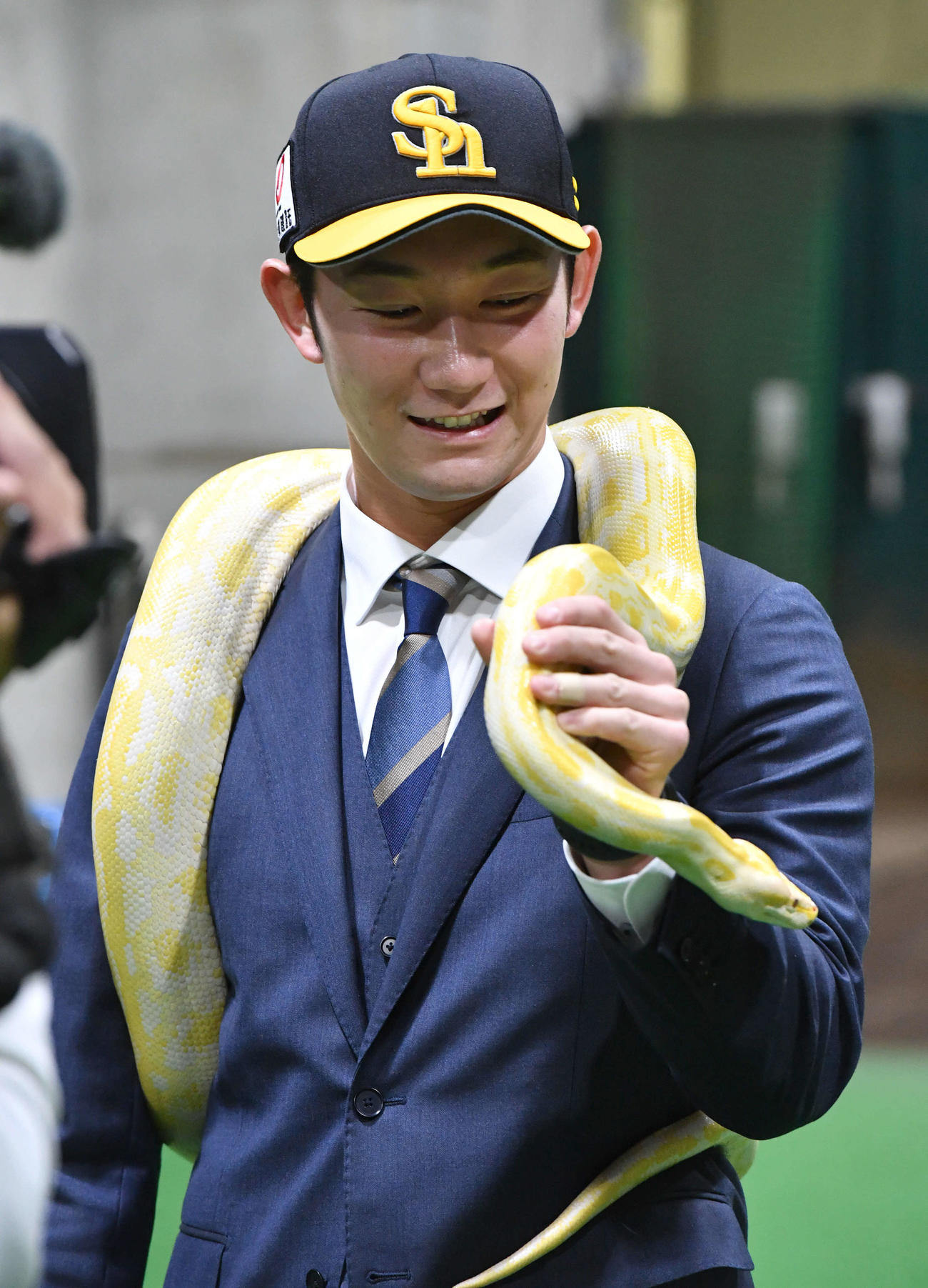 幸運を呼ぶとされるビルマニシキヘビを肩に巻く正木（撮影・岩下翔太）