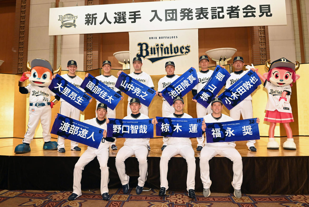 自身のタオルを手に記念写真に納まるオリックス新入団選手（前列左から）渡部、野口、椋木、福永（後列左から）大里、園部、山中、1人おいて池田、横山、小木田（撮影・前岡正明）