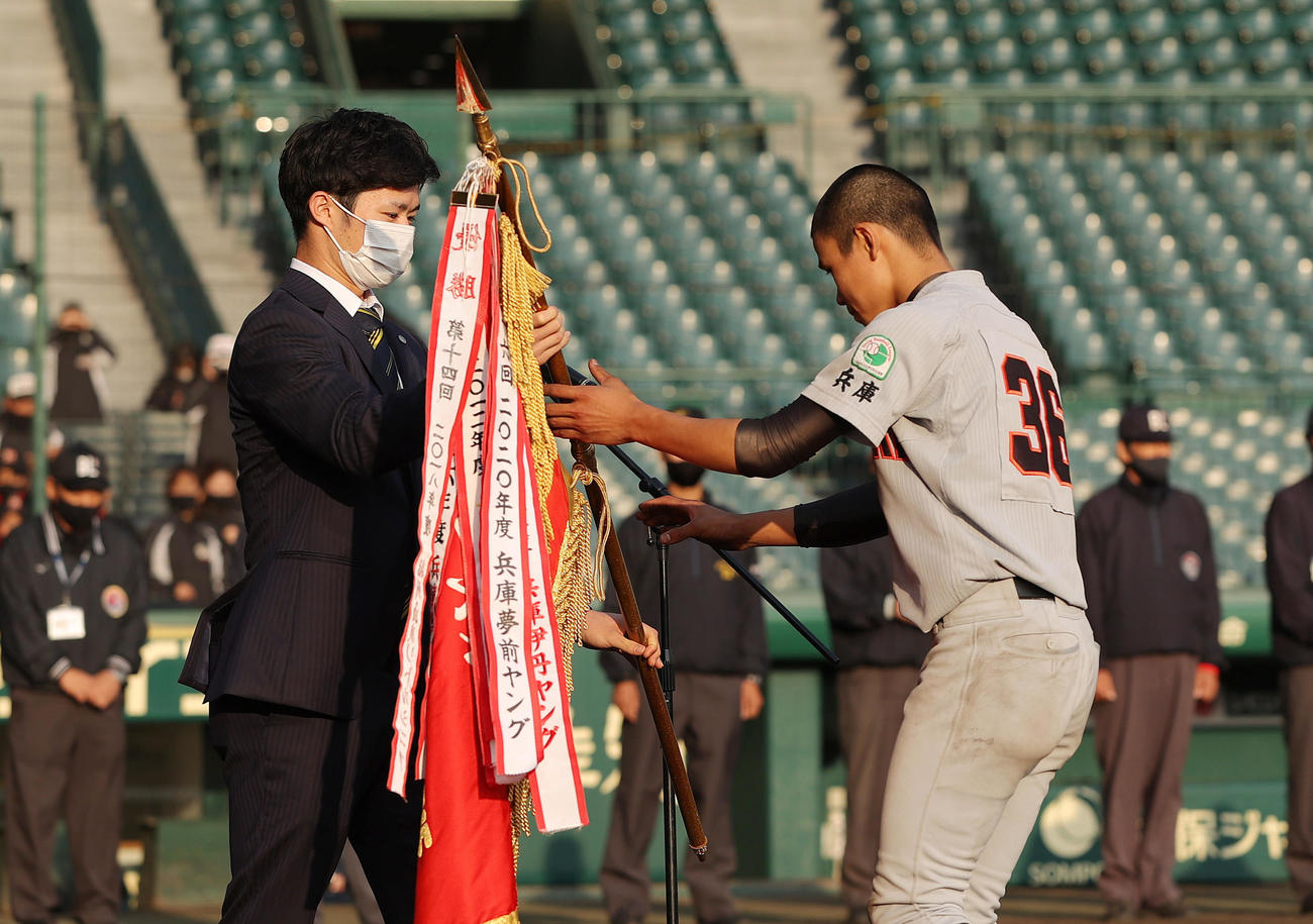 タイガースカップの表彰式でプレゼンターを務め、選手に優勝旗を渡す阪神中野（左）（撮影・前田充）