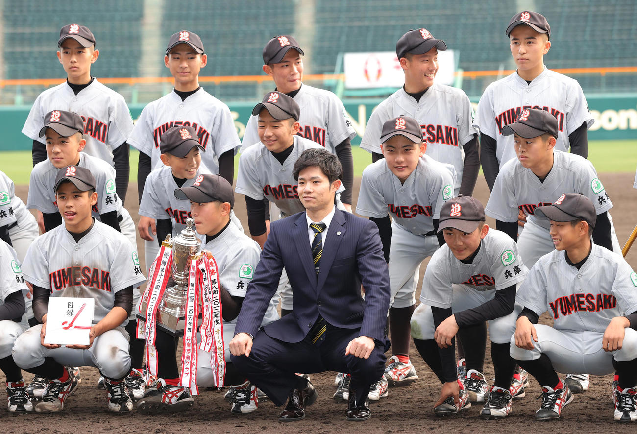 タイガースカップの表彰式で、優勝した兵庫夢前ヤングの選手たちと記念撮影する阪神中野（前列中央）（撮影・前田充）