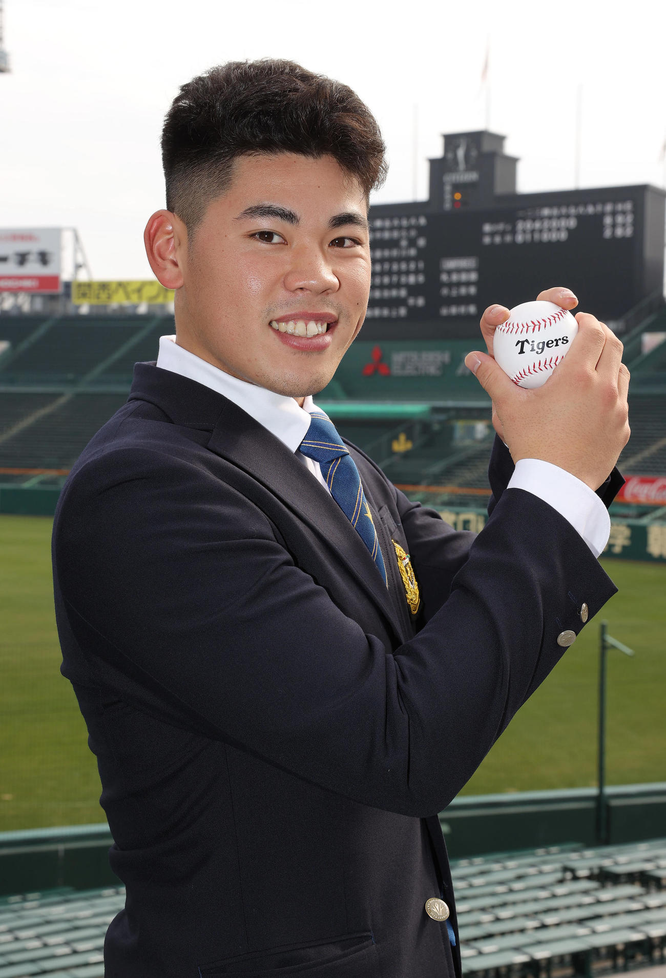 甲子園球場の施設見学を行い笑顔でポーズを決める鈴木（撮影・前田充）