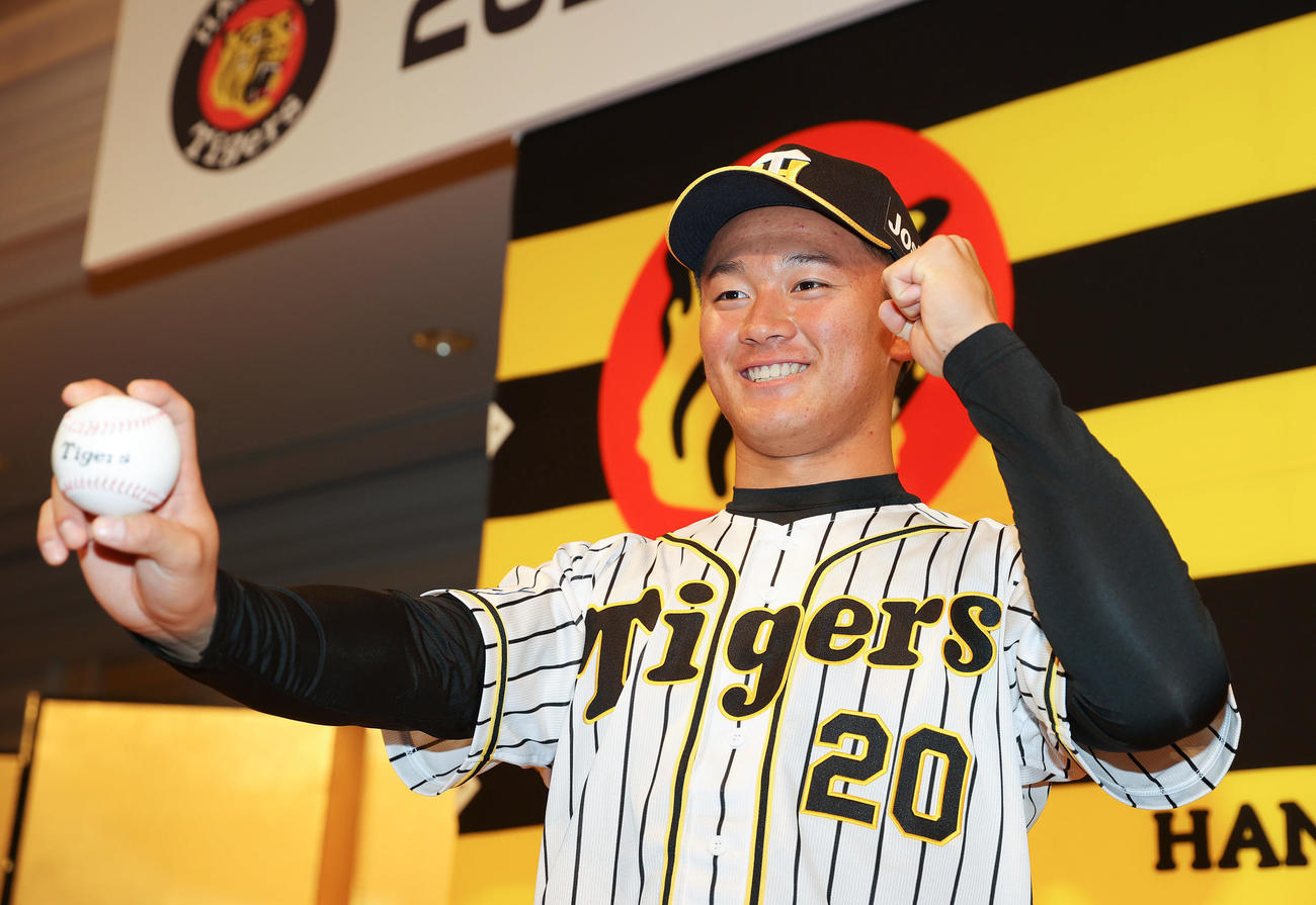新人選手入団発表会で笑顔でポーズを決めるドラフト1位の阪神森木（撮影・前田充）