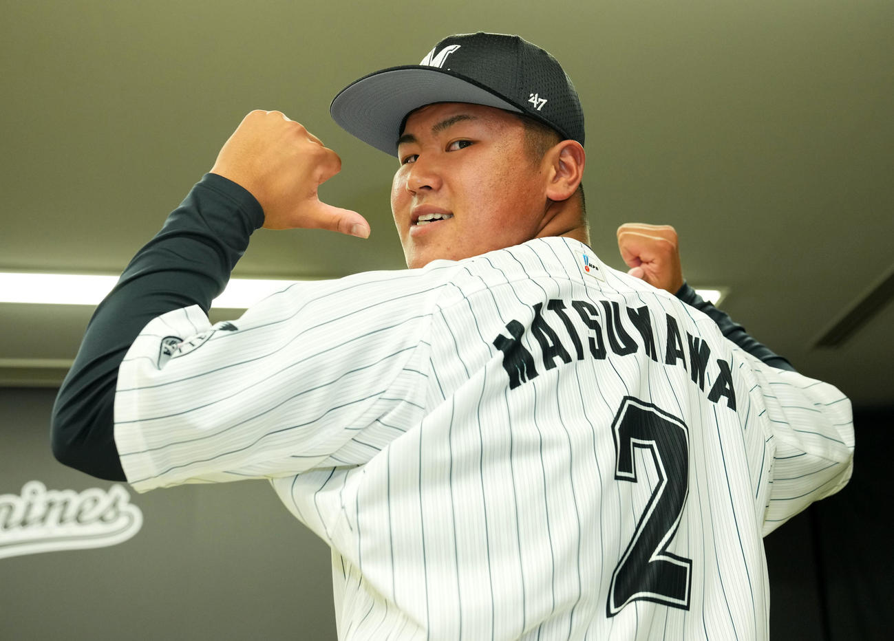 背番号2番を見せ笑顔を見せるロッテドラフト1位の市和歌山・松川（2021年12月9日撮影）