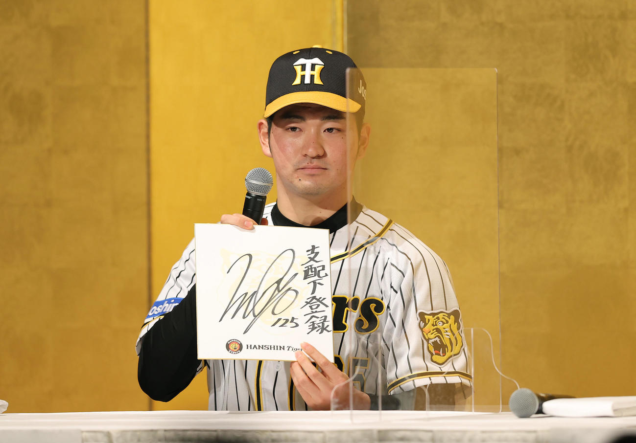 新人選手入団発表会を終え、ファンミーティングで「支配下登録」と目標を記した色紙を披露する育成ドラフト1巡目の阪神伊藤稜（撮影・前田充）