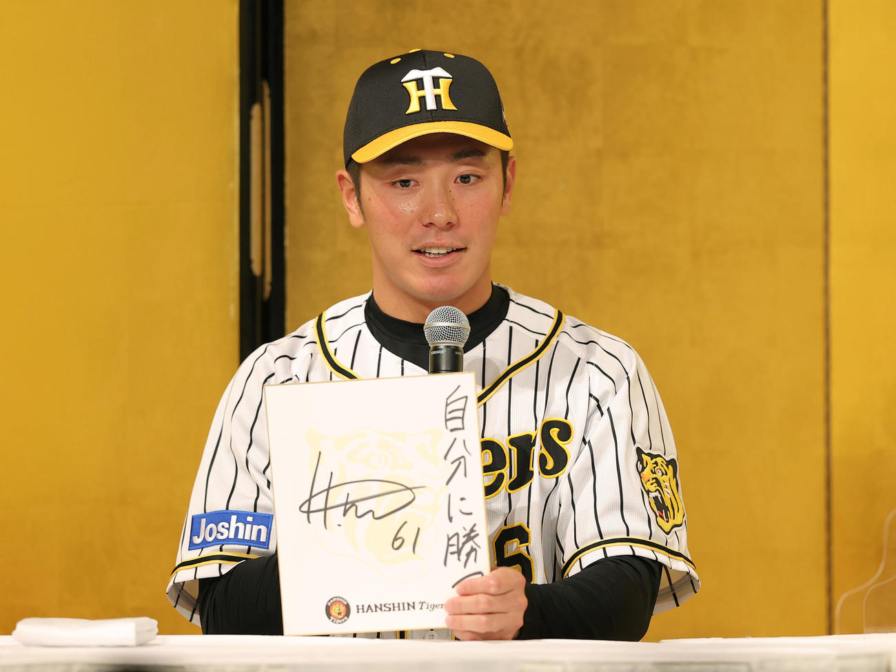 新人選手入団発表会を終え、ファンミーティングで「自分に勝つ」と目標を記した色紙を披露するドラフト6巡目の阪神豊田（撮影・前田充）