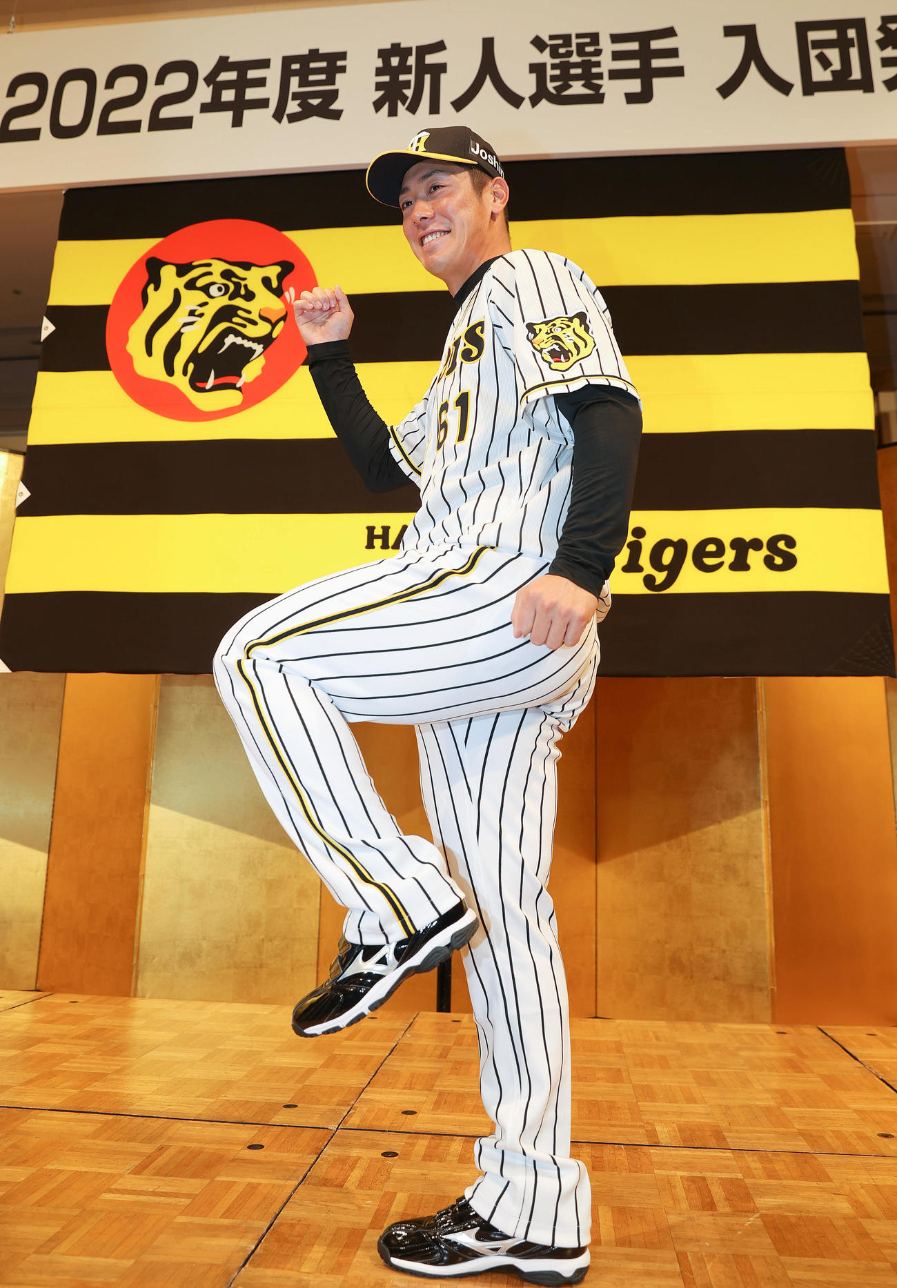 新人選手入団発表会で笑顔でポーズを決めるドラフト6巡目の阪神豊田（撮影・前田充）