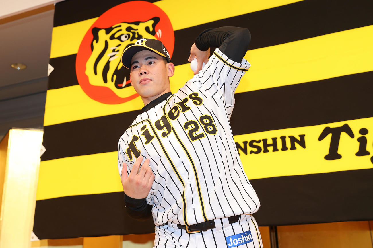 新人選手入団発表会でポーズを決めるドラフト2巡目の阪神鈴木（撮影・前田充）
