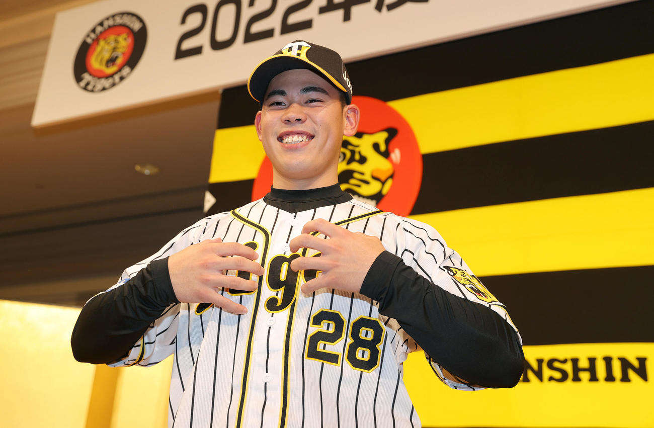 新人選手入団発表会で笑顔でゴリラポーズを決めるドラフト2巡目の阪神鈴木（撮影・前田充）