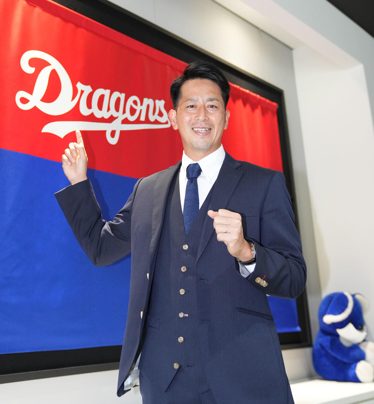 中日ドラゴンズへ育成契約で入団が決まり球団旗の前でポーズを決める大嶺（撮影・森本幸一）