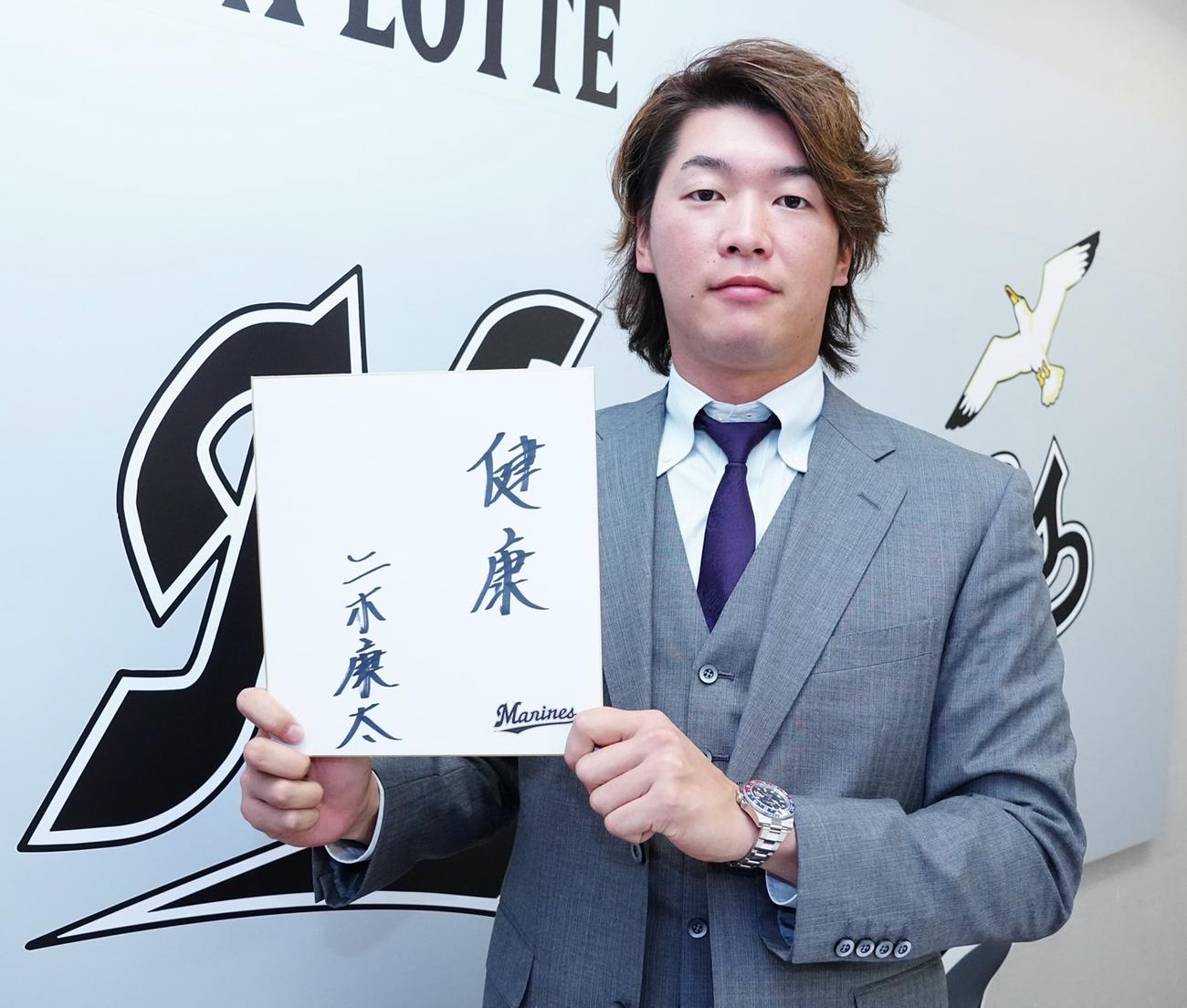 契約更改会見で色紙に「健康」としたためたロッテ二木