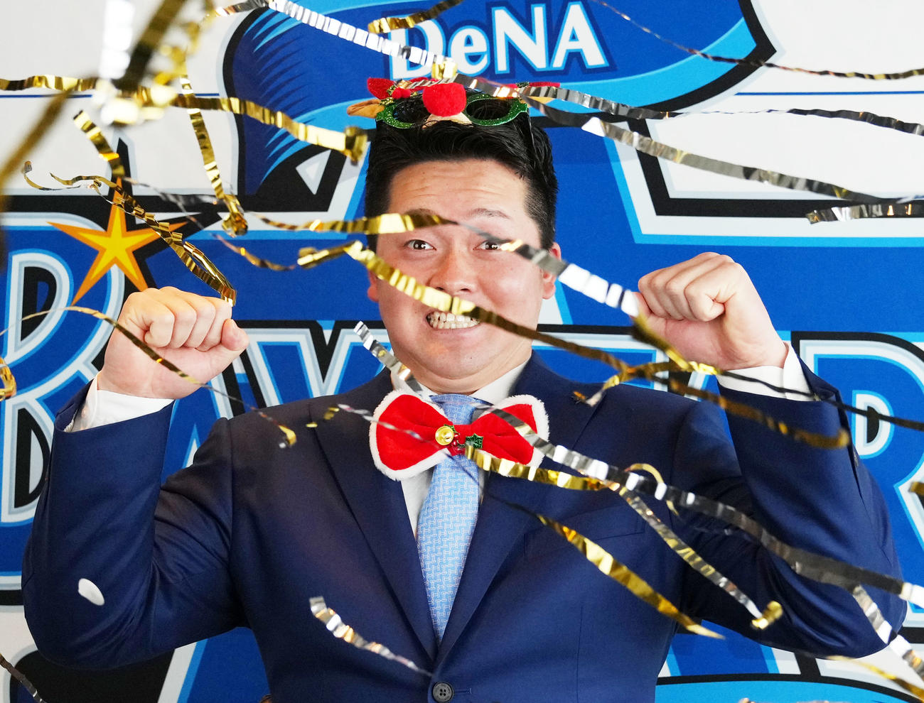 契約更改を終え、会見で金のシャワーテープを浴びるDeNA牧秀悟（撮影・横山健太）