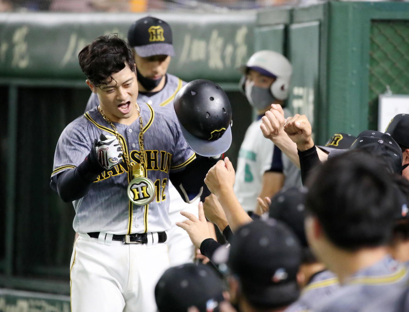 10月13日、巨人戦で阪神坂本は左越え本塁打を放ち、メダルを胸にナインに迎えられる