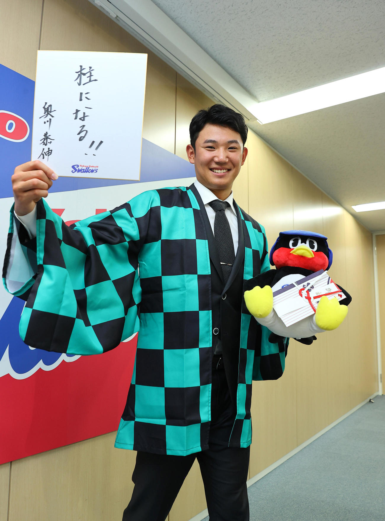 契約更改を終え「柱になる」と記した色紙を手にポーズを取るヤクルト奥川（代表撮影）