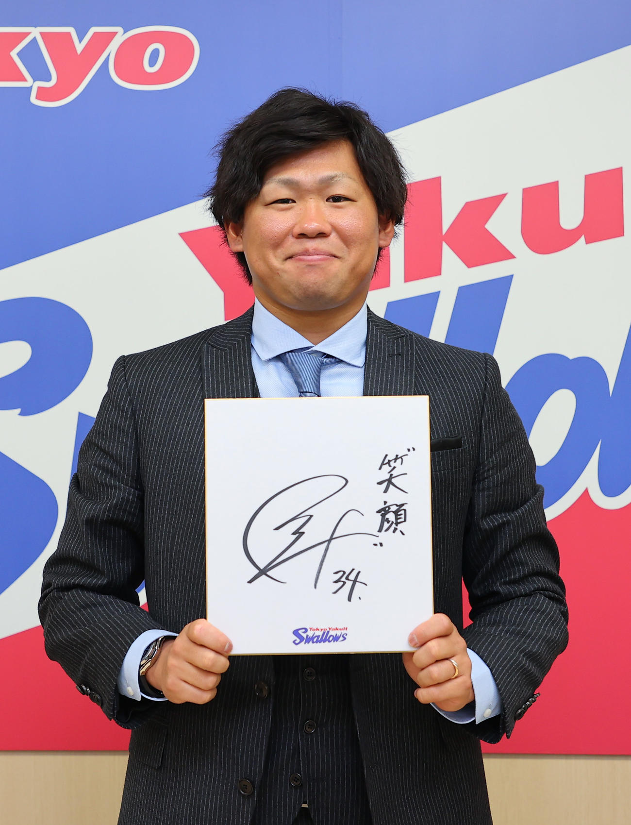契約更改を終え、「笑顔」と記した色紙を手に写真撮影に臨む田口麗斗（代表撮影）