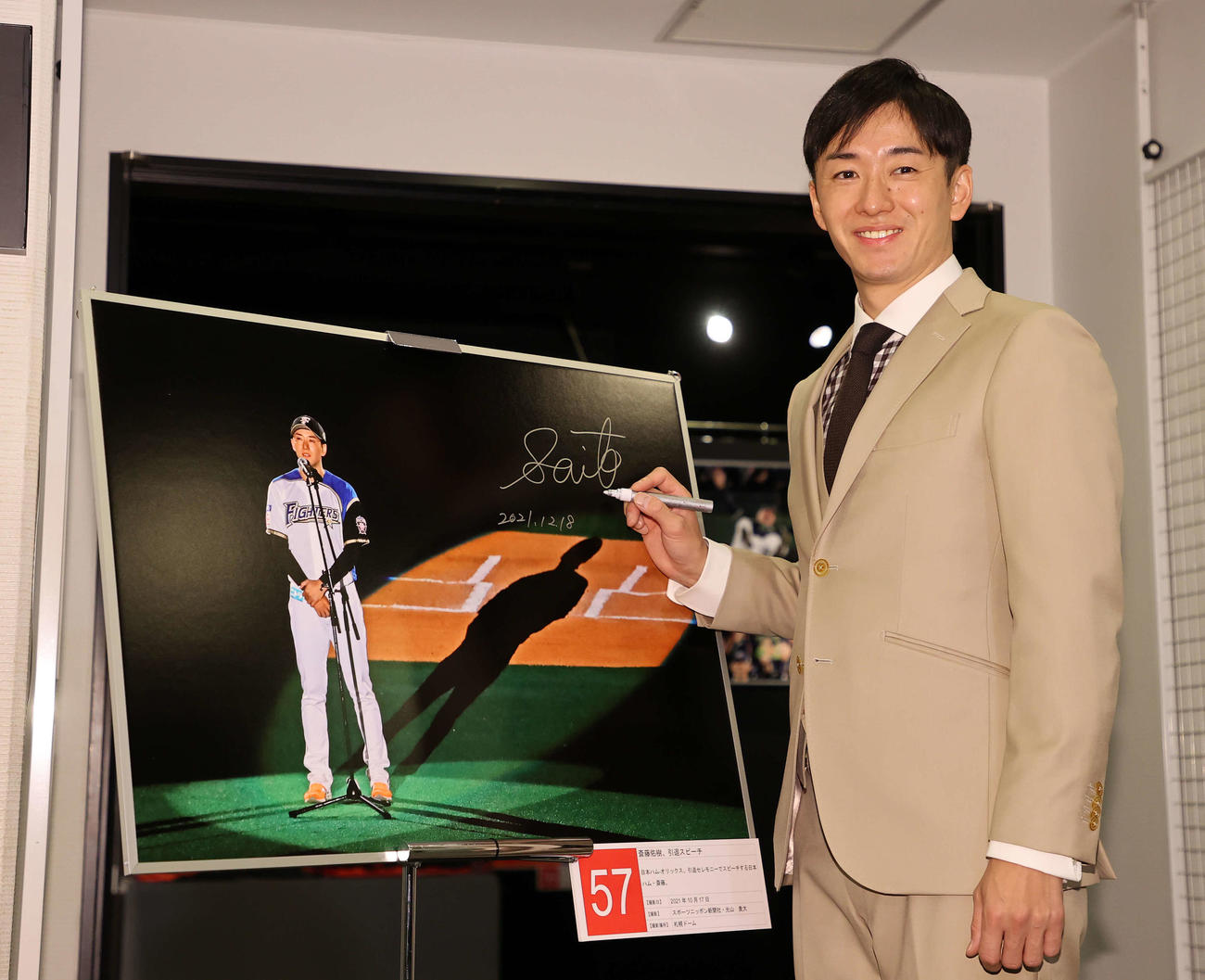 引退セレモニーの写真にサインし笑顔を見せる斎藤氏（撮影・鈴木正人）