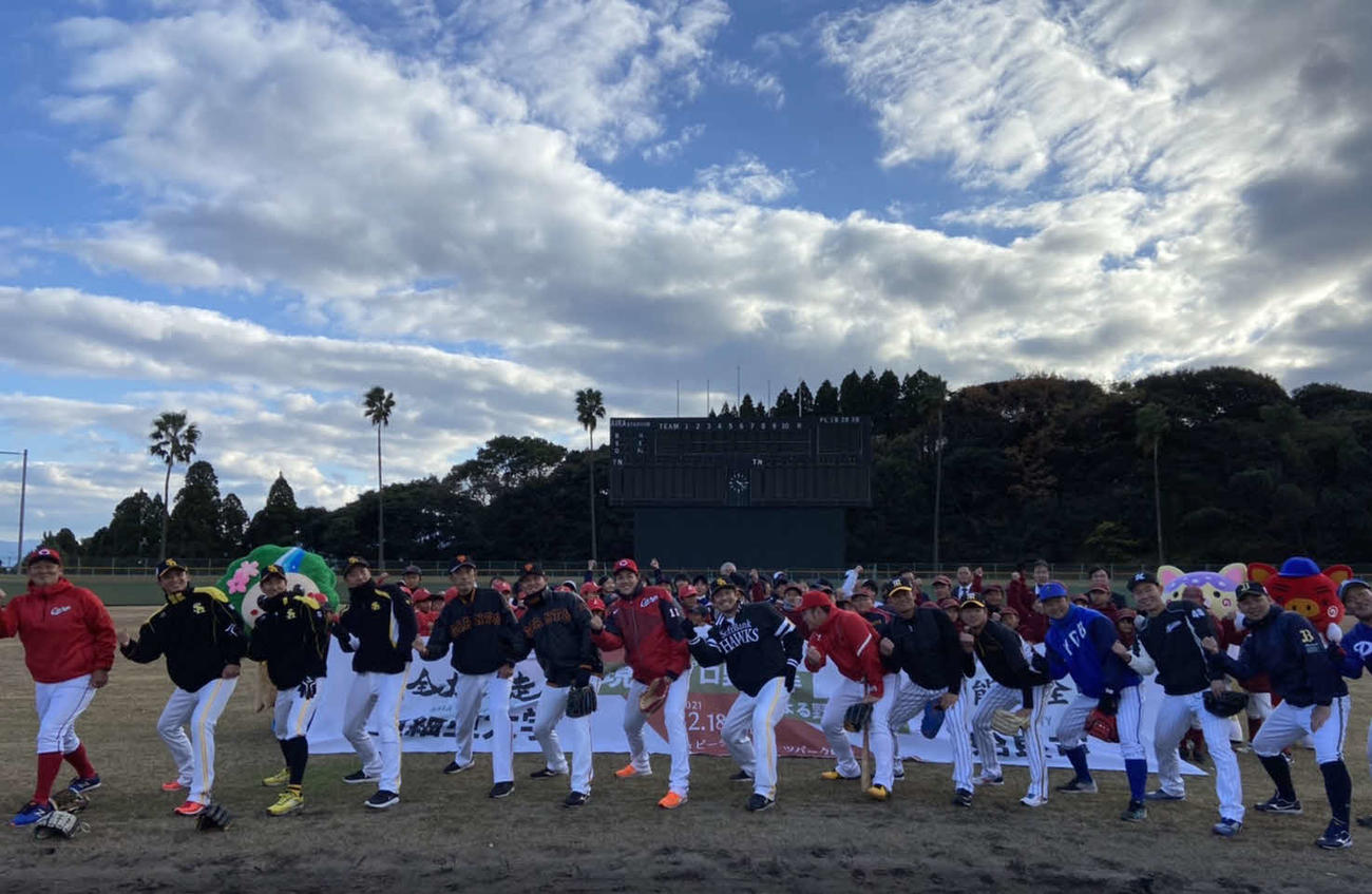 鹿児島・姶良市内での野球教室に参加し、「熱男」ポーズを見せるソフトバンク松田（前列中央）ら亜大OBと背後の子どもたち（撮影・小早川宗一郎）