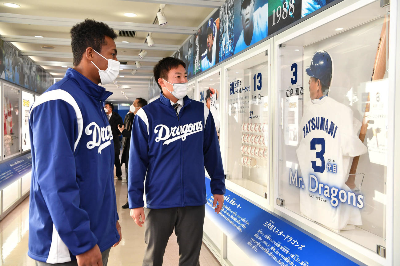 施設見学で本拠地バンテリンドームを訪れ場内の立浪監督の展示物を見つめるブライト健太（左）と鵜飼
