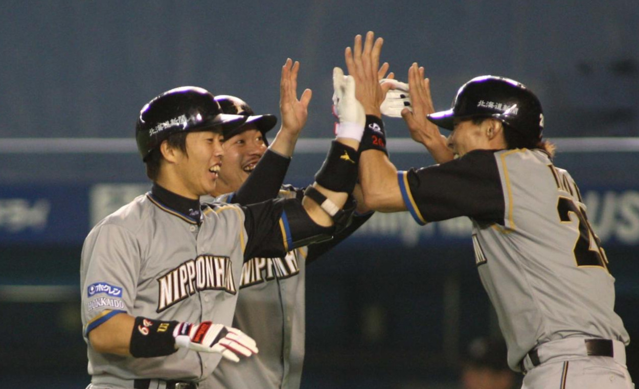 糸井嘉男、小谷野栄一と打者鶴岡慎也がハイタッチ（09年撮影）