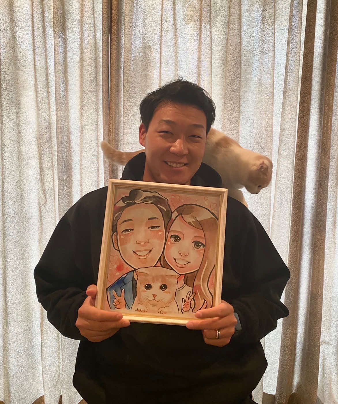 阪神大山は作家マナムさんが描いた愛妻梨子さん、愛猫ラテとの似顔絵を手に笑顔