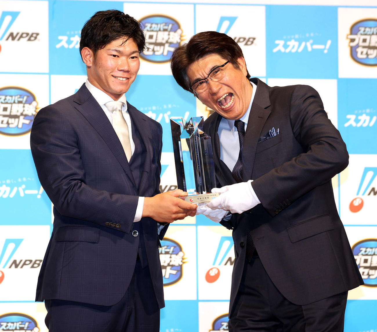「2021スカパー！ドラマティック・サヨナラ賞　年間大賞表彰式」でプレゼンターの石橋貴明（右）からトロフィーを授与され笑顔を見せる広島の坂倉（撮影・浅見桂子）