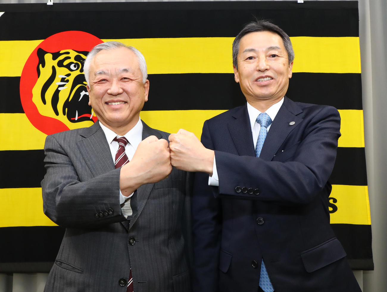 藤原オーナー兼球団社長（左）とグータッチを交わす新たに代表取締役球団社長に就任する百北常務取締役（代表撮影）