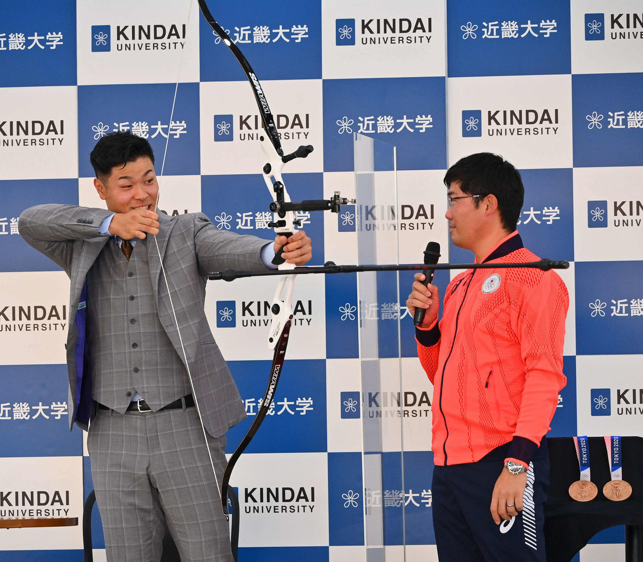 東京五輪アーチェーリー銅メダリスト古川（右）の指導を受けながら弓を引く阪神佐藤輝（撮影・上田博志）